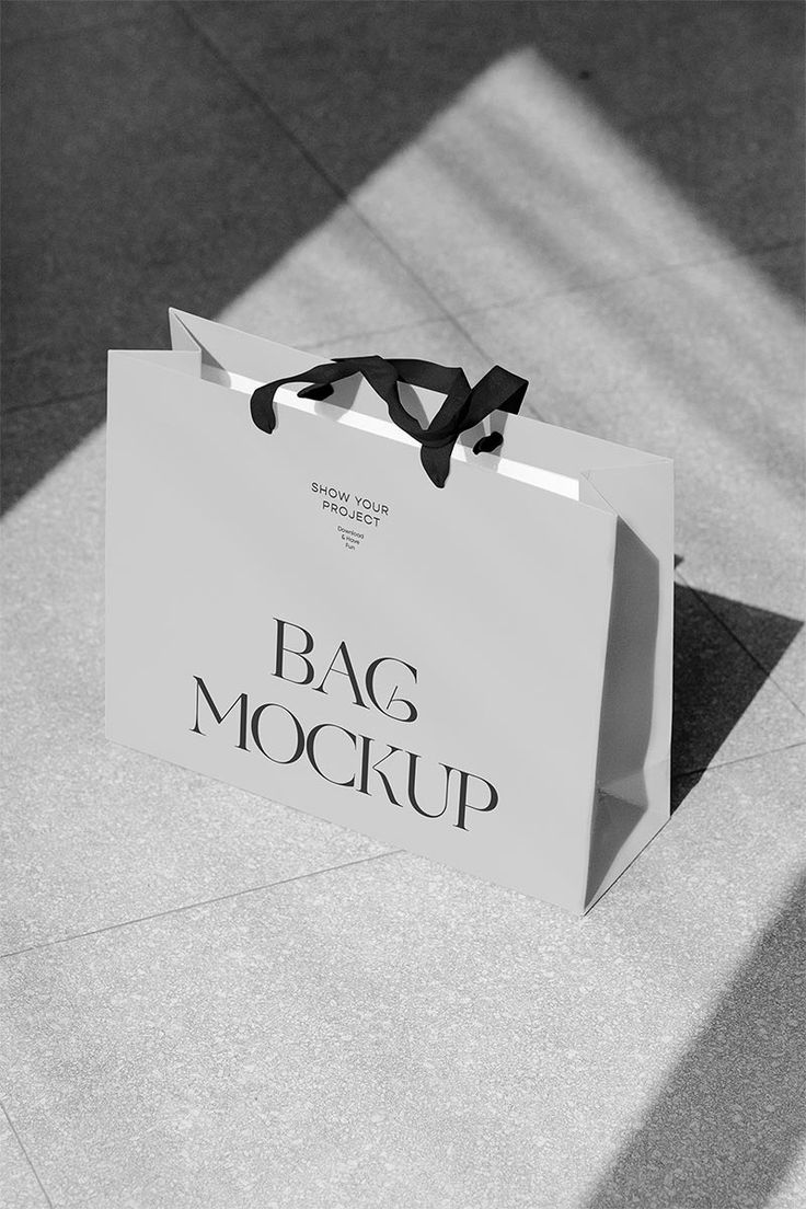 a black and white photo of a bag mockup on the ground with its tag tied to it