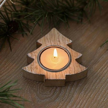 a small wooden candle holder with a lit candle in the shape of a christmas tree