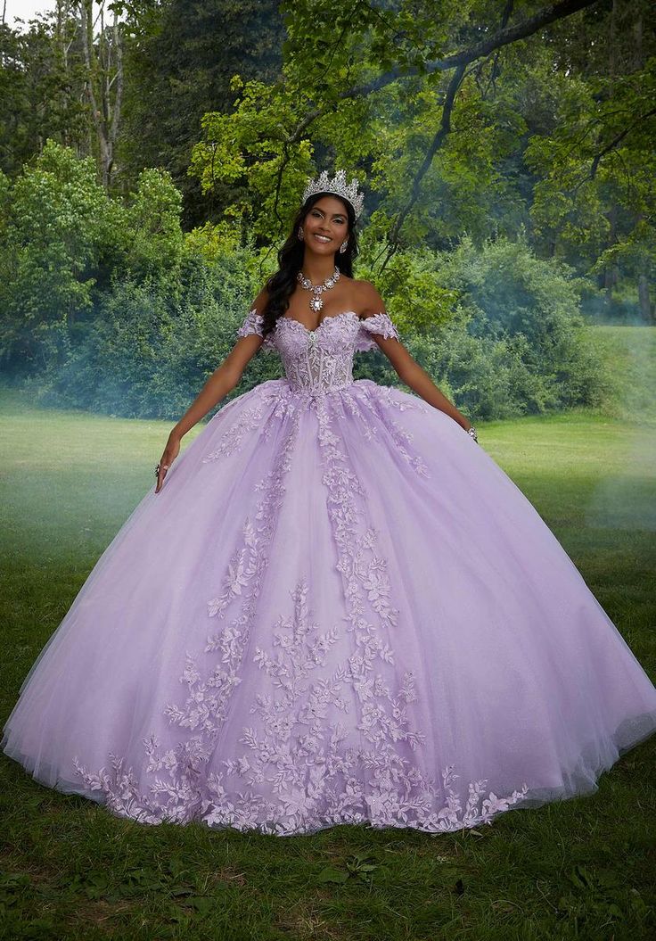 This Vizcaya ball gown is a breathtaking choice for your quinceaera, adorned with exquisite details that will make you feel like royalty. Floral appliqus crafted from crystal beaded lace cascade romantically down the sweetheart bodice, drawing attention to the sheer midriff that showcases the intricate couture boning. A sparkling brooch adorns the center of the bodice, adding a touch of dazzling elegance.The magic continues with the skirt, made from luxurious sparkle tulle that shimmers with eve Quinceanera Dresses Blush Elegant, Repunzal Dress, Lilac Quince, Lilac Quinceanera Dresses, Lavender Quinceanera Dresses, Purple Quinceanera Dresses, Debut Dresses, Rapunzel Dress, Floral Embellishment