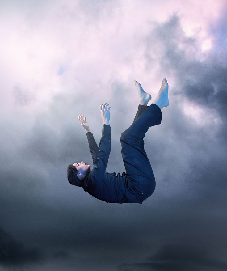 a man flying through the air on top of a surfboard under a cloudy sky