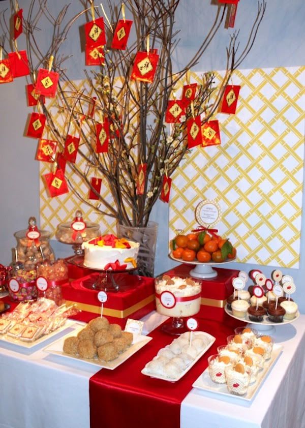 a table topped with cakes and desserts next to a tree