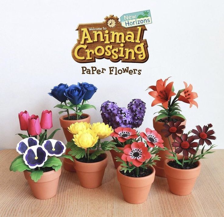 several potted plants with fake flowers in front of the sign for an animal crossing