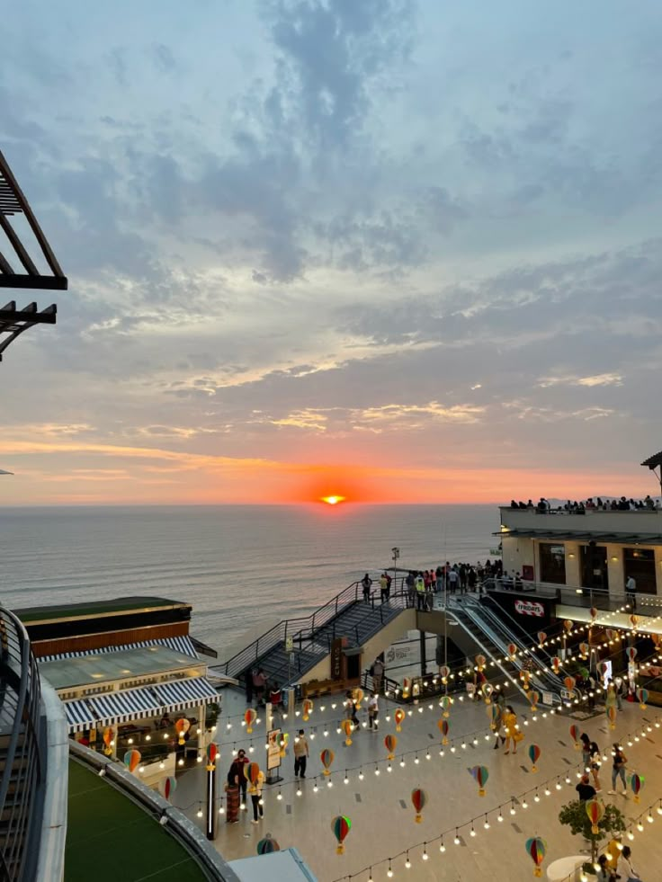 the sun is setting over an ocean side restaurant