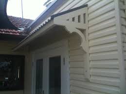 an outside view of a house with a white door and window on the right side