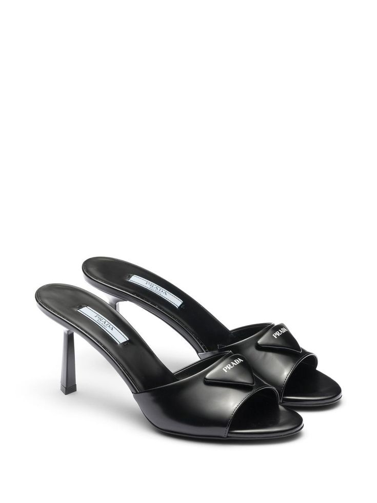 Find PRADA Leather Heeled Mules on Editorialist. black calf leather brushed finish triangle logo slip-on style open toe branded insole high heel Elegant Open Toe Calf Leather Slides, Chic Formal Calf Leather Slides, Black Luxury Mules With Sculpted Heel, Luxury Black Mules With Sculpted Heel, Formal Open Toe Calf Leather Slides, Formal Calf Leather Open Toe Slides, Formal Open-toe Calf Leather Slides, Elegant Leather Slides With Sculpted Heel, Luxury Slides With Padded Heel