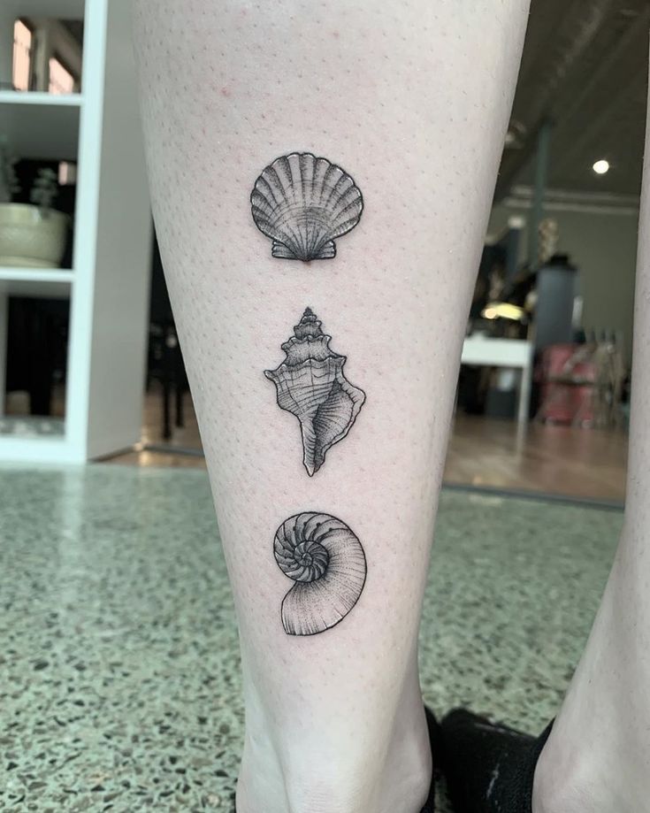 three seashells tattoo on the left leg and one shell on the right side