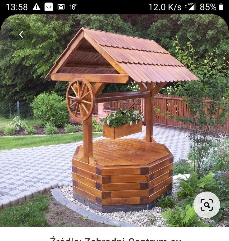 a wooden gazebo sitting on top of a lush green field