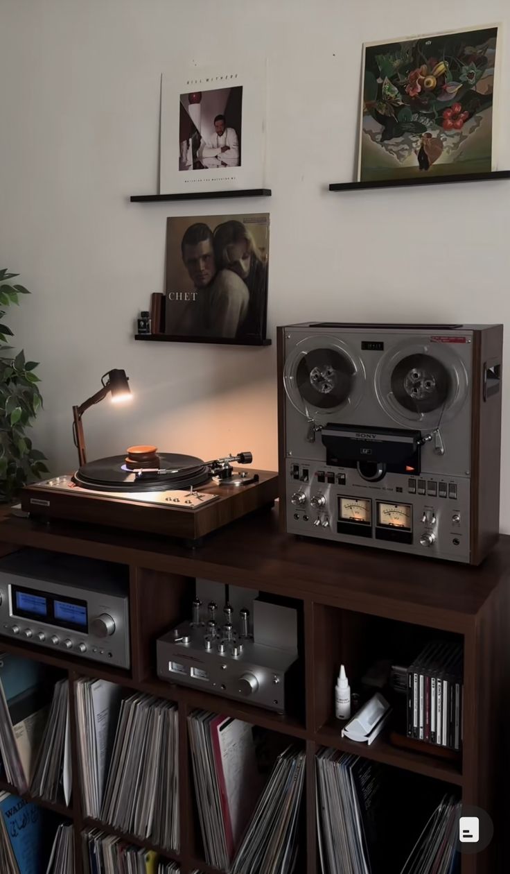 a record player sitting on top of a wooden shelf