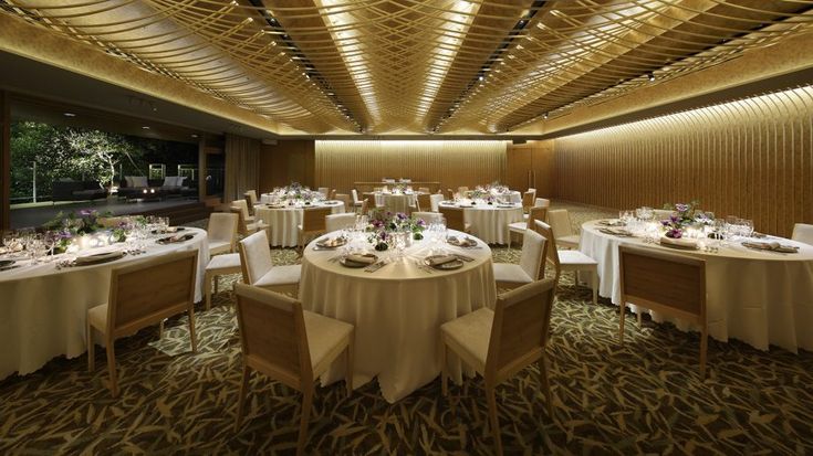 a large room with tables and chairs set up for a formal function in the evening