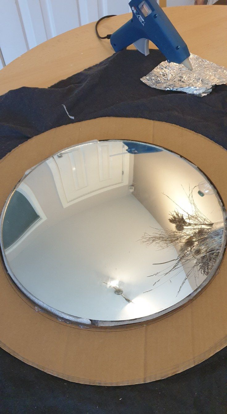 a round mirror sitting on top of a wooden table