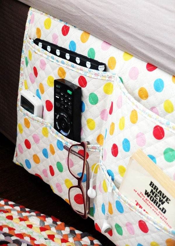 a cell phone is in the pocket of a polka dot purse that's attached to a bed