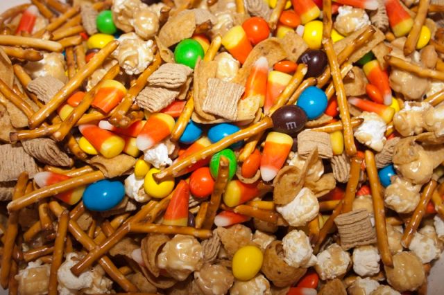 a bowl filled with lots of colorful candy and candies on top of wooden sticks