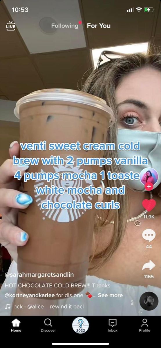 a woman holding up a cup of coffee in front of her face with the caption