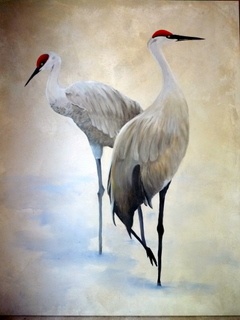 two white birds standing next to each other on a painting board in front of a wooden frame