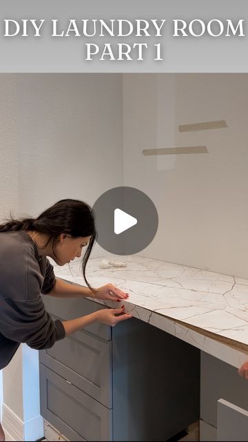 a woman standing in front of a white counter top next to a man holding a knife