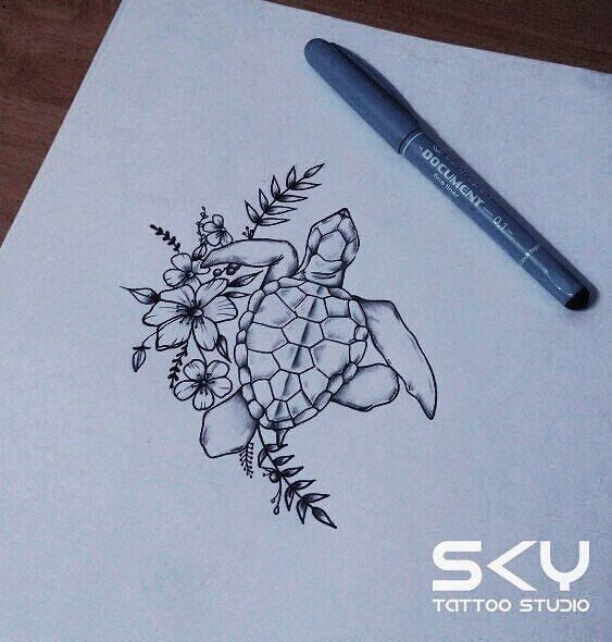 a drawing of a turtle and flowers on a piece of paper with a marker next to it