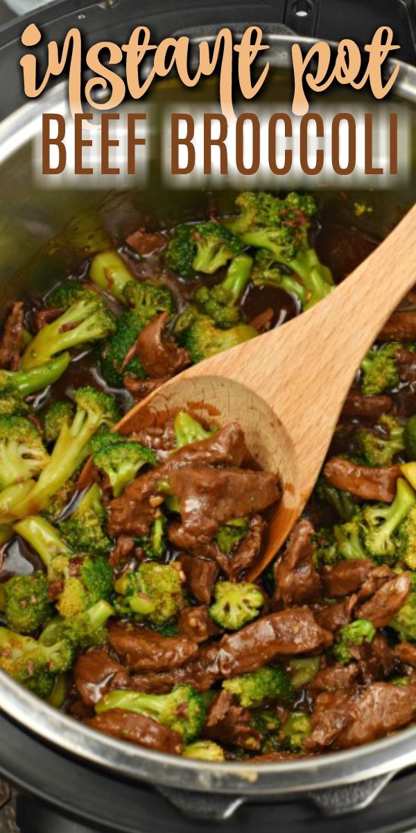 beef and broccoli is cooking in a pot with a wooden spoon on the side