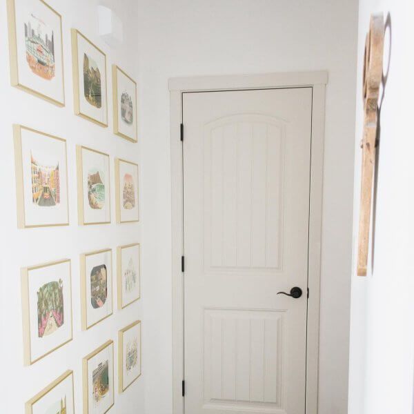 a white door in a room with pictures on the wall