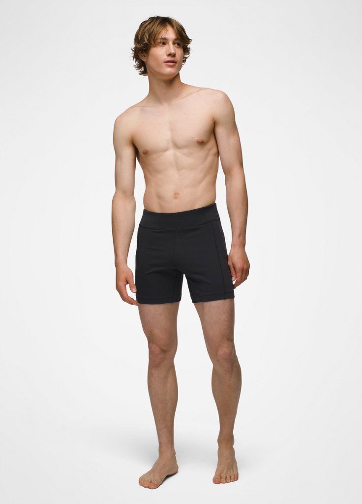 a man in black trunks and no shirt is standing with his hands on his hips