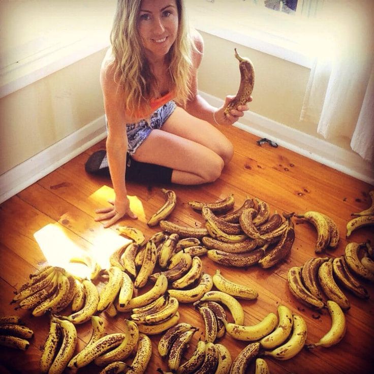 a woman sitting on the floor surrounded by bananas