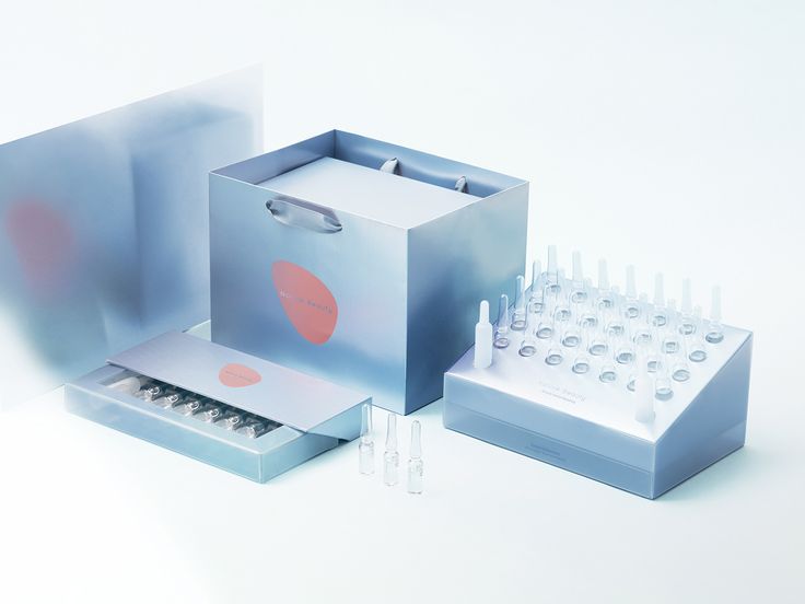 an assortment of bottles and tubes are arranged in a box on a white surface,