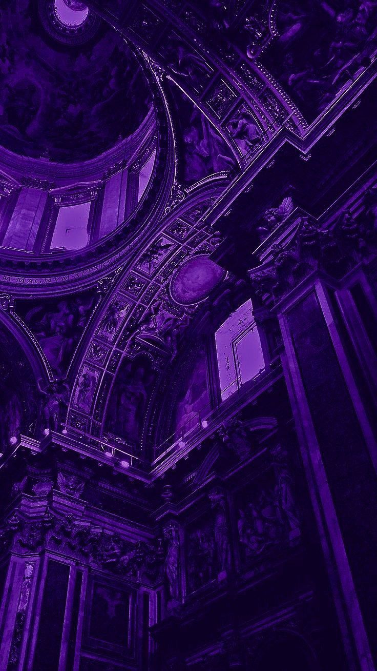 the interior of an old building with purple lighting and intricate carvings on the ceiling,