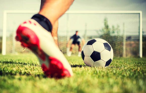 two people are playing soccer on the grass