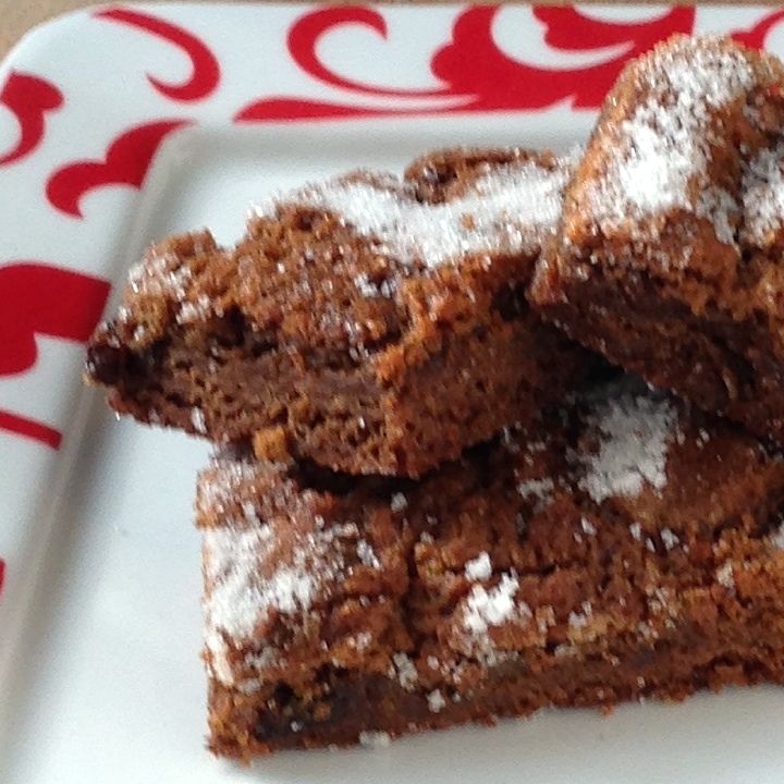 some brownies are on a plate with powdered sugar