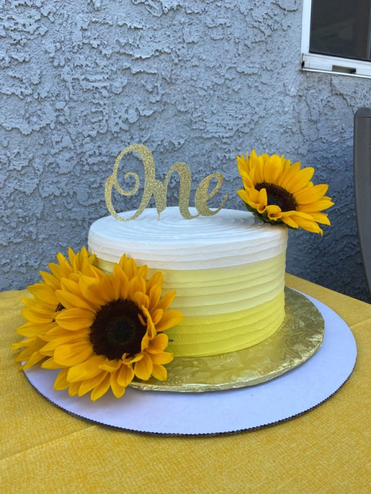 a yellow and white cake with two sunflowers on top