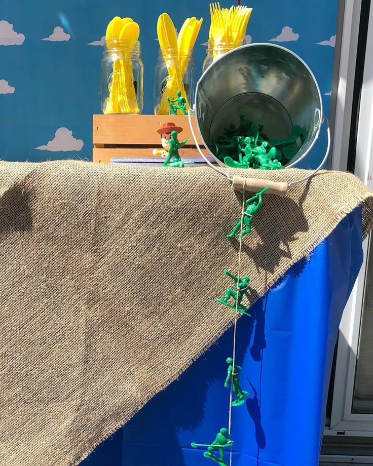 the table is set up with yellow flowers and plastic straws on it for decoration