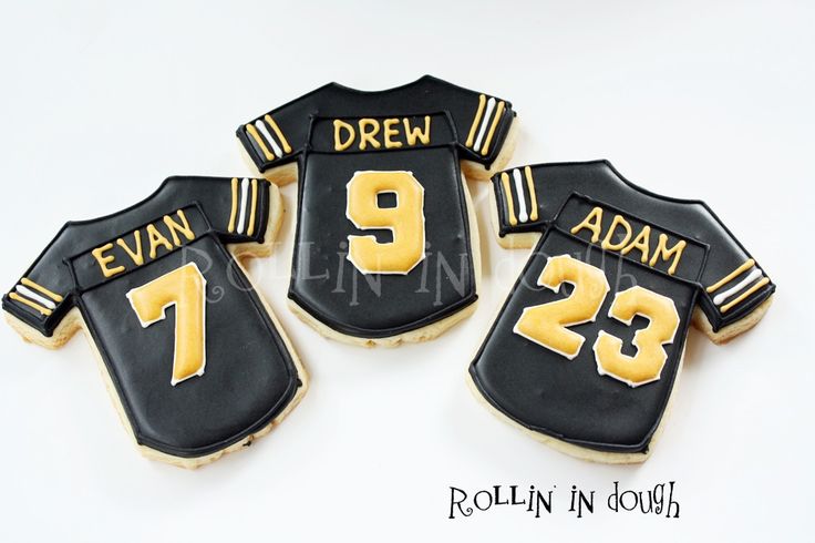 three decorated cookies in the shape of football jerseys with name and number on them