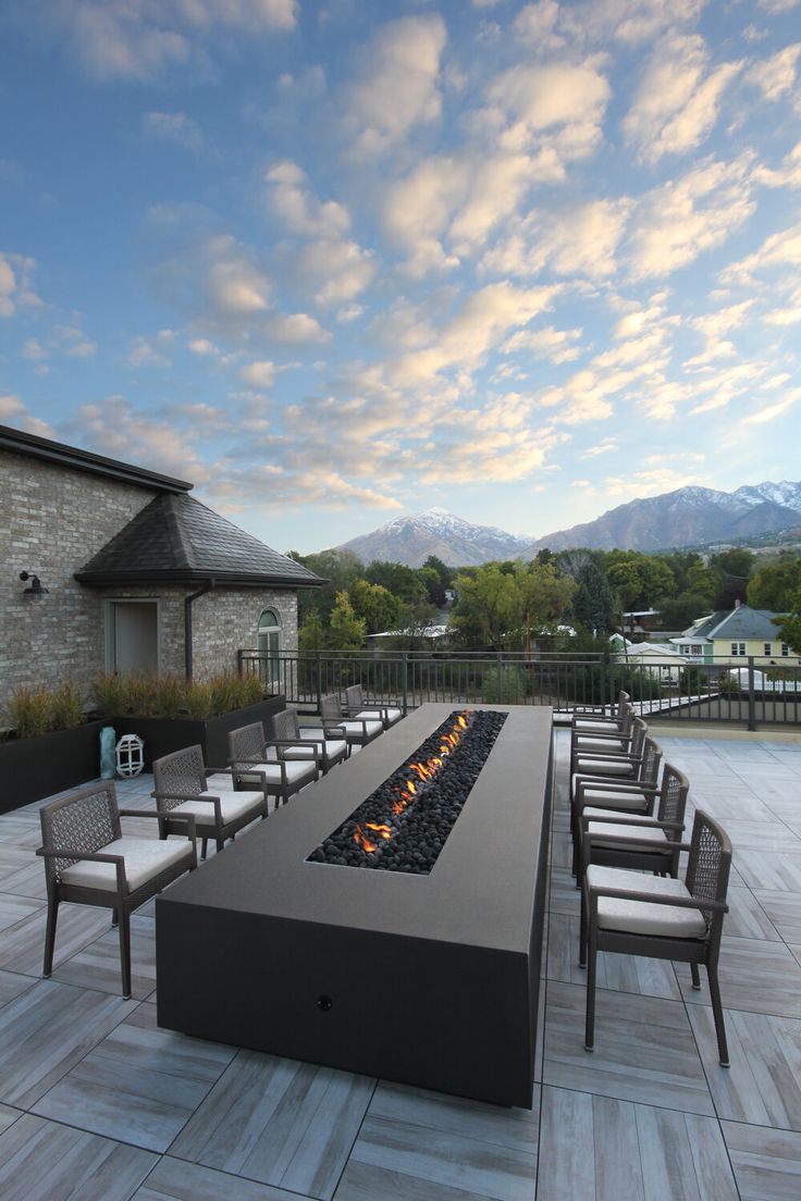 an outdoor fire pit with chairs around it