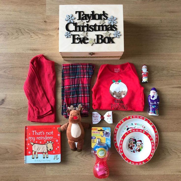 the contents of a christmas eve box laid out on a wooden floor with toys and other items