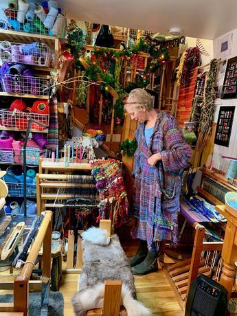 a woman standing in a room filled with lots of items