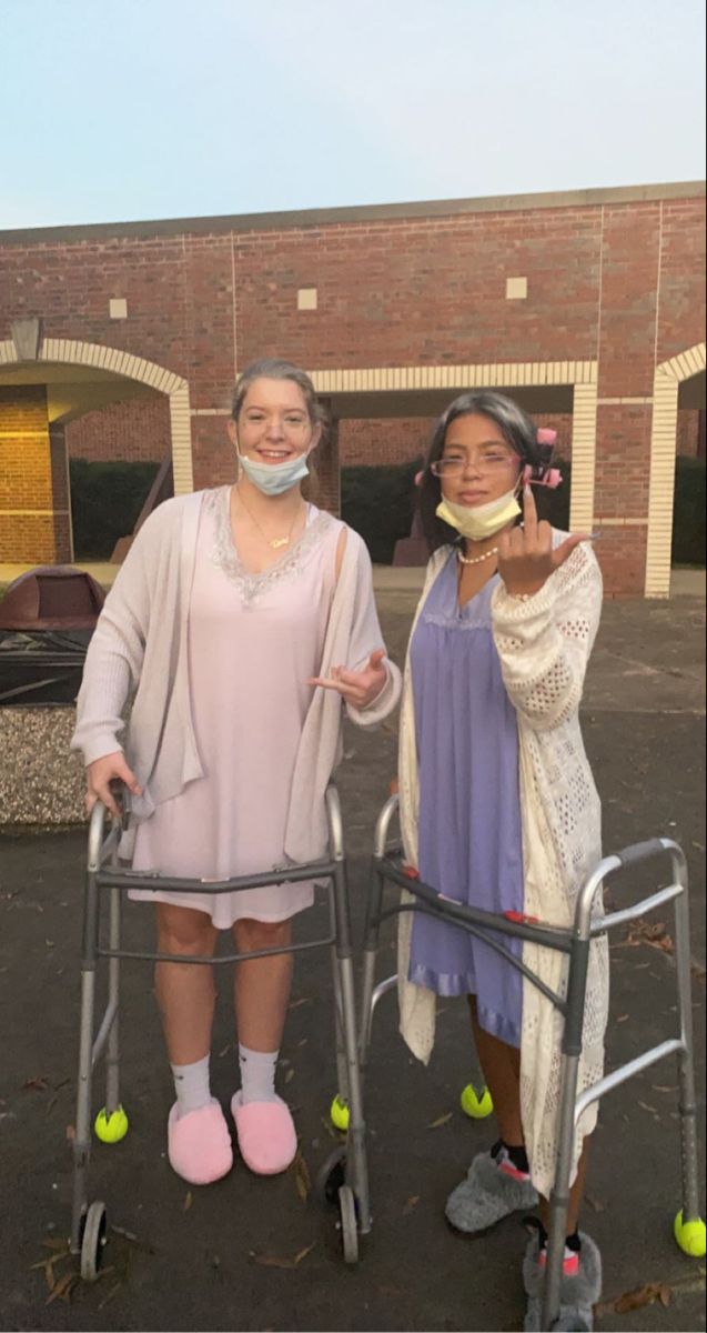 two women standing next to each other with crutches on their hands and wearing face masks