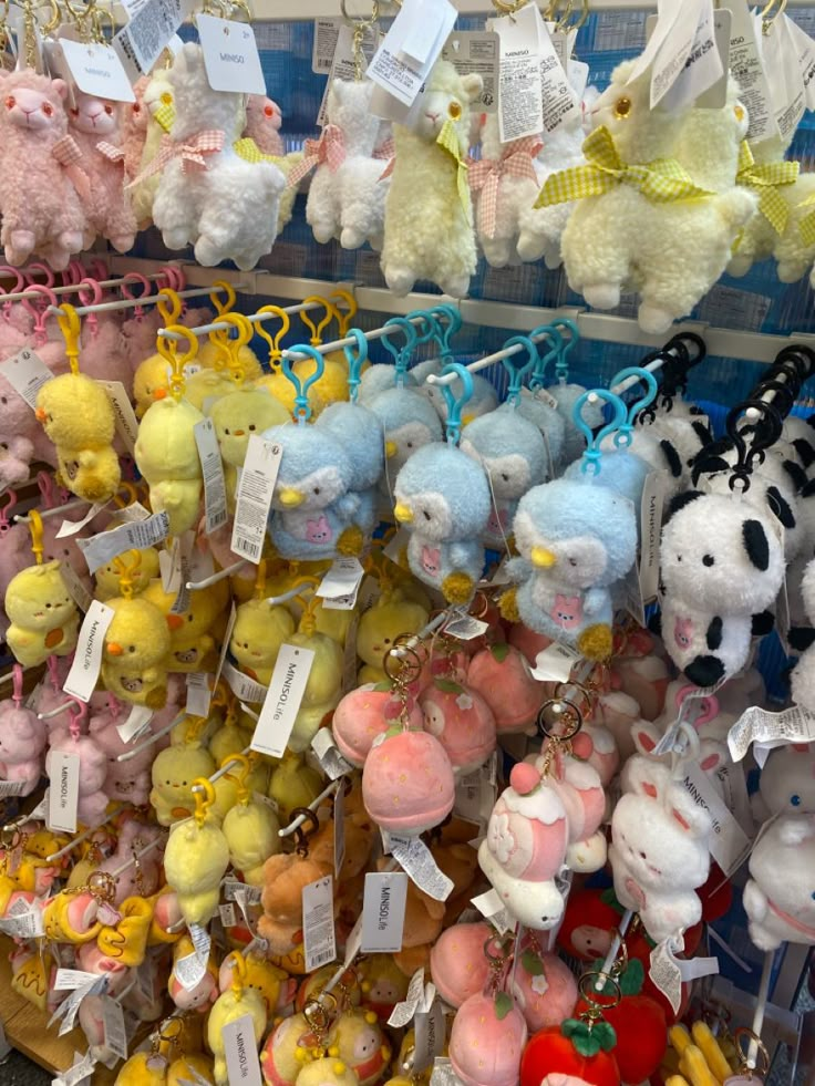 many stuffed animals are on display in a toy store, with price tags attached to them