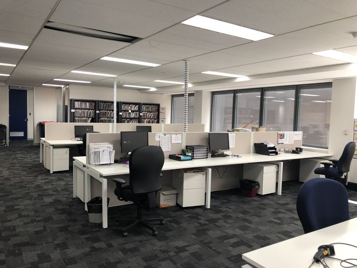 an office cubicle with two desks and computers