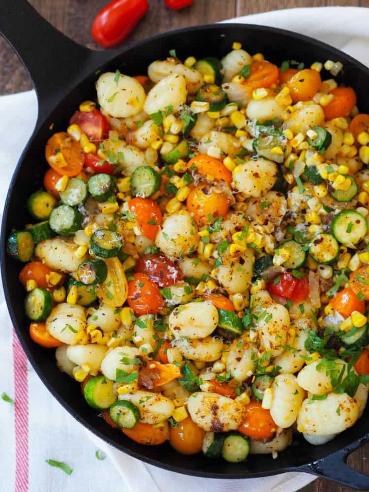 a skillet filled with corn and vegetables