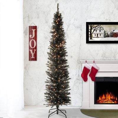 a decorated christmas tree in front of a fireplace