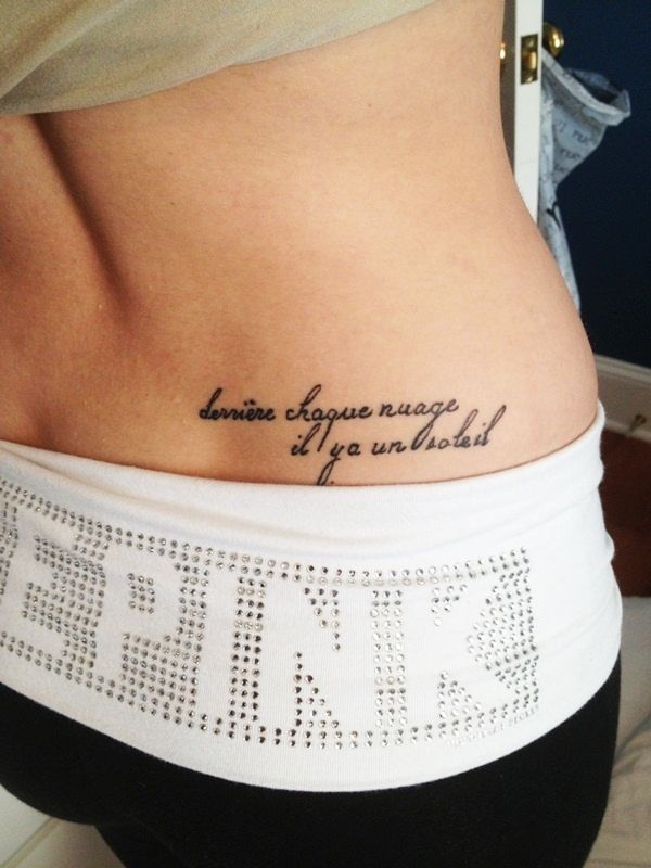 a woman's lower back tattoo with words written on it