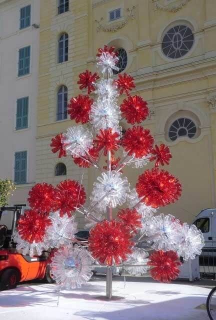 a red and white christmas tree in front of a building