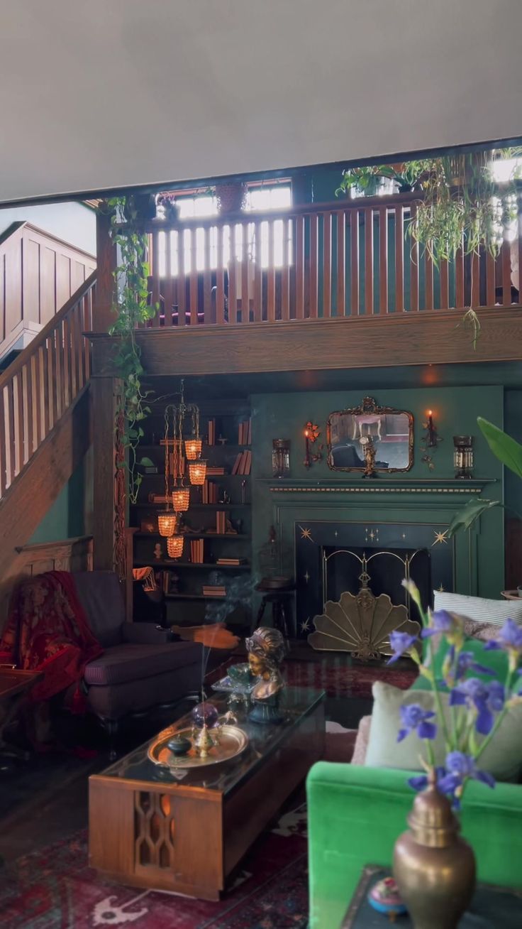 a living room filled with furniture and a fire place next to a stair case in front of a green wall