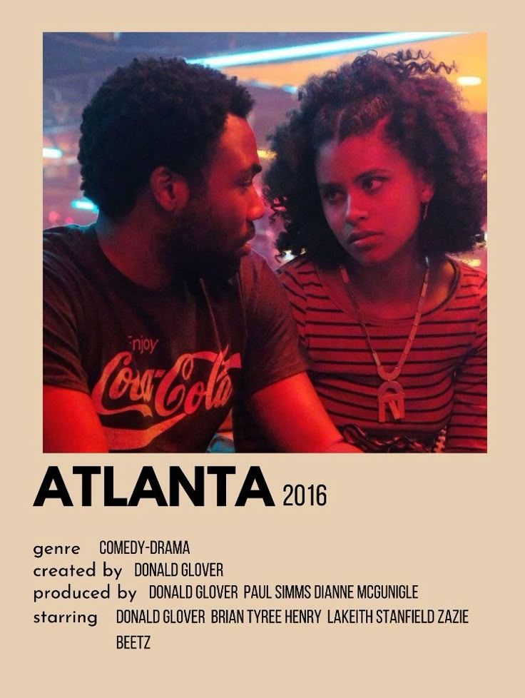 a man and woman sitting next to each other in front of a sign that says atlanta