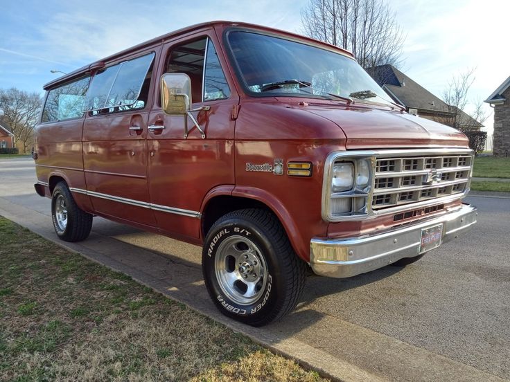 an old red van is parked on the side of the road in front of a house