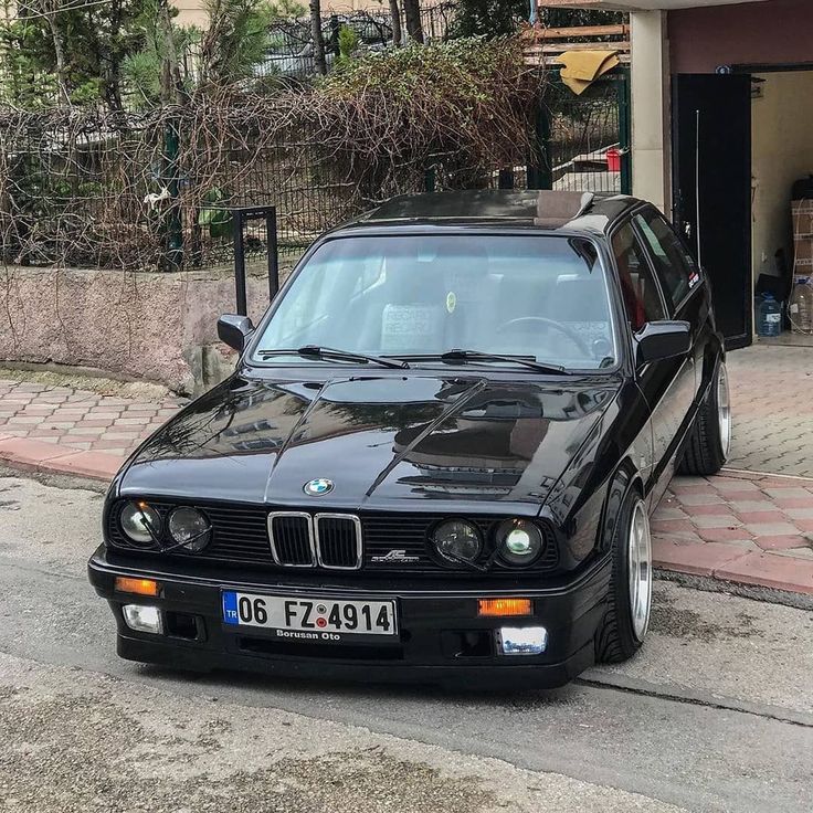 a black car is parked on the side of the road