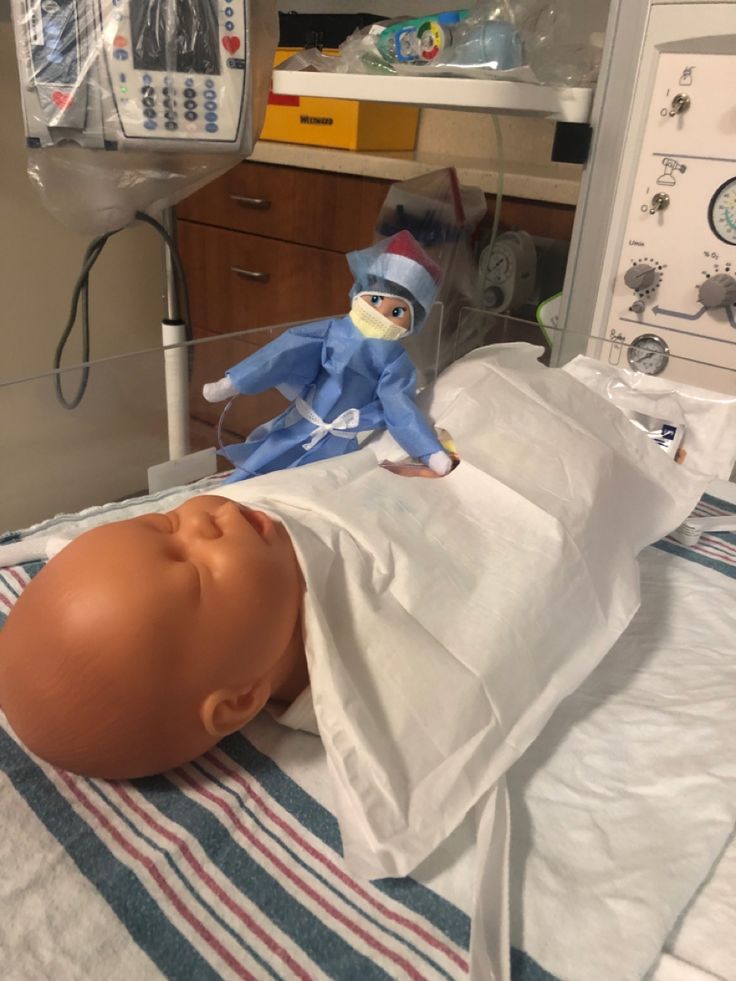 an infant doll laying on top of a hospital bed