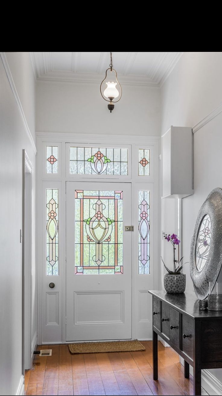 an entryway with stained glass windows and wooden floors