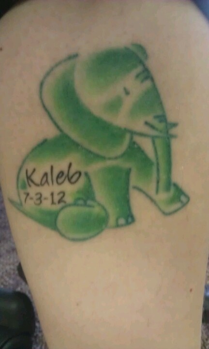 an elephant tattoo with the name kaleb on it's back side leg