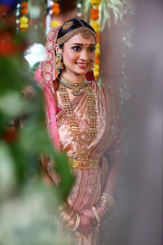 a woman in a pink and gold bridal outfit