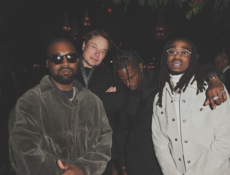 three men standing next to each other in front of a group of people wearing sunglasses